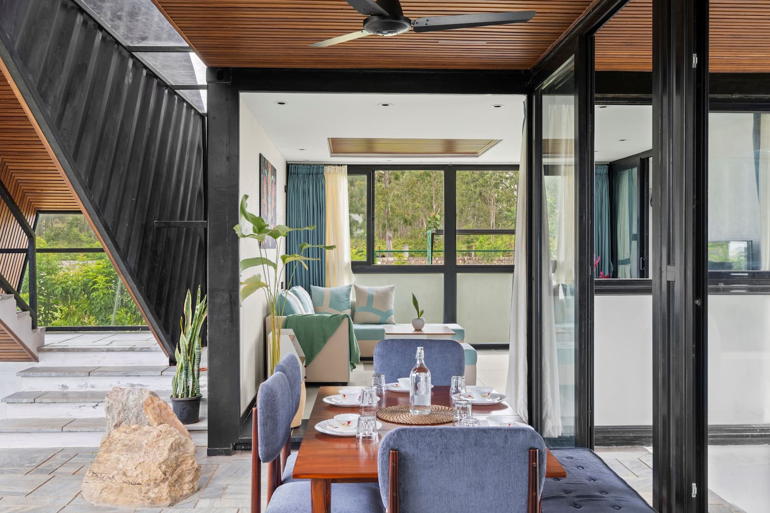 Dining area with set table viewed through full-height glass sliding doors